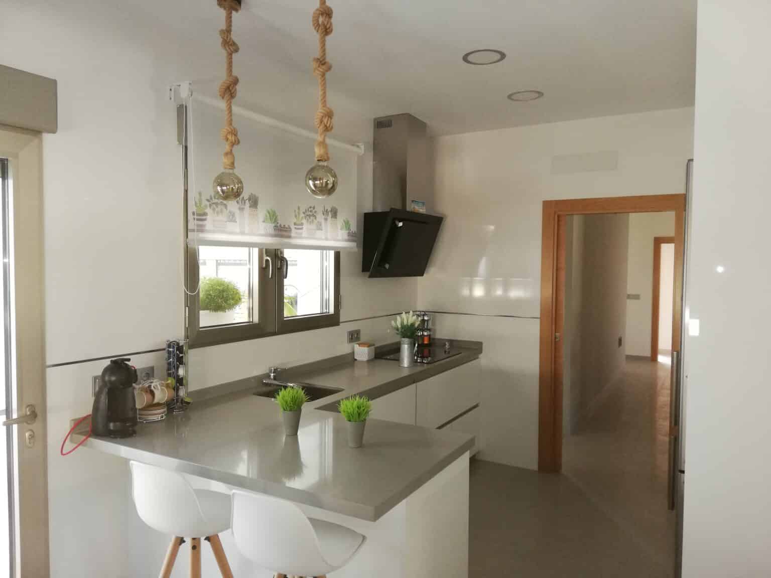 Cocina blanca a medida con península, realizada por Ébano Galería